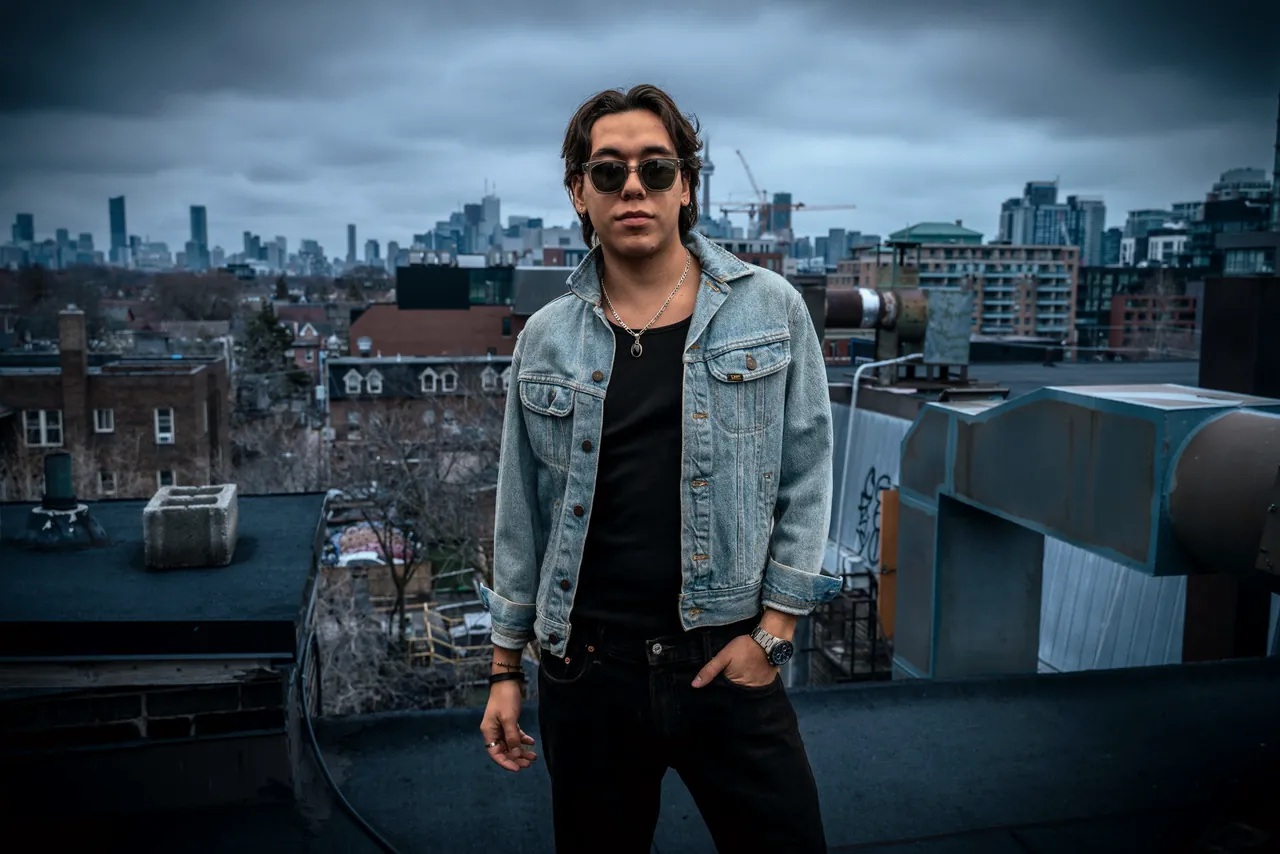 Zeegwon Shilling on a Toronto rooftop, the city skyline behind him