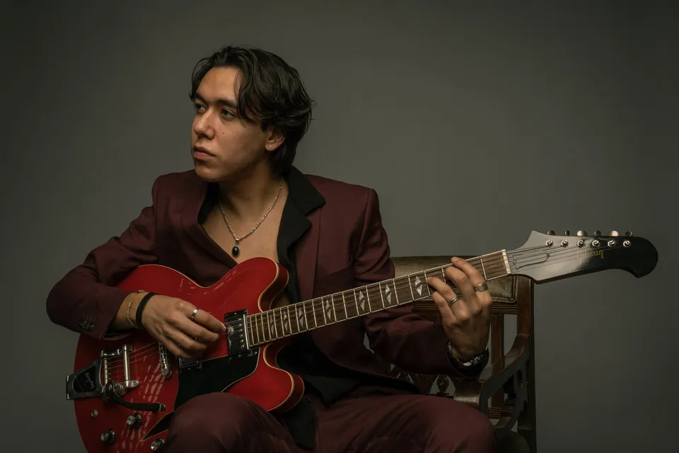 Zeegwon Shilling playing his red Gibson guitar